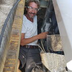 Thomas Grunewald in a small space between wall and tub, installing necessary connections.